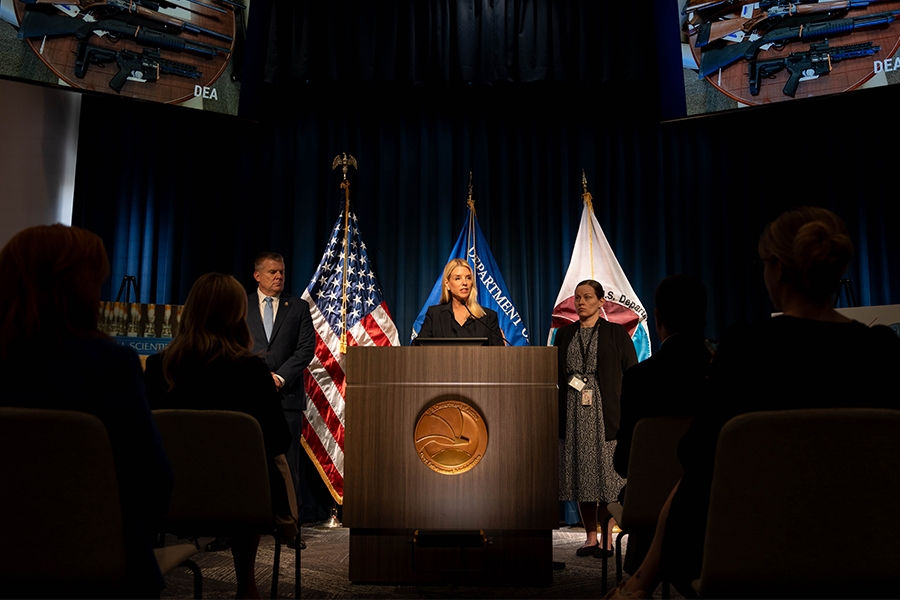 Attorney General Pamela Bondi delivers remarks from a podium at the Drug Enforcement Administration Headquarters. She is joined by DEA Acting Administrator Robert J. Murphy.