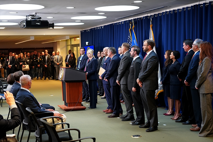 Attorney General Pamela Bondi delivers remarks from a podium at the U.S. Attorney’s Office for the Eastern District of New York. She is joined by federal government officials.