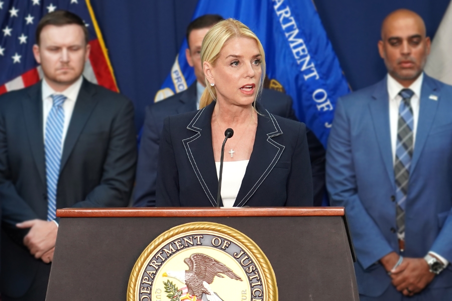 Attorney General Pamela Bondi delivers remarks from a podium at the U.S. Attorney’s Office for the Eastern District of New York. She is joined by federal government officials.