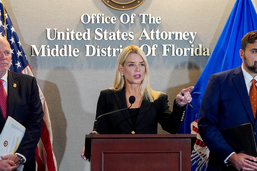 Attorney General Pamela Bondi delivers remarks from a podium at the U.S. Attorney’s Office for the Middle District of Florida. She is joined by federal government officials.