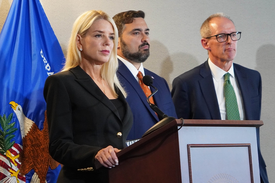 Attorney General Pamela Bondi delivers remarks from a podium at the U.S. Attorney’s Office for the Middle District of Florida. She is joined by federal government officials.